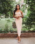 Nude color, figure hugging, long dress has thin adjustable sling and scoop neck. 
