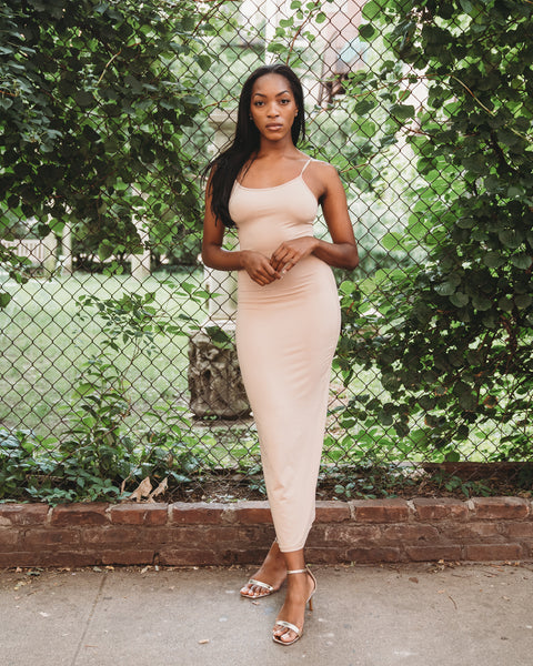 Nude color, figure hugging, long dress has thin adjustable sling and scoop neck. 