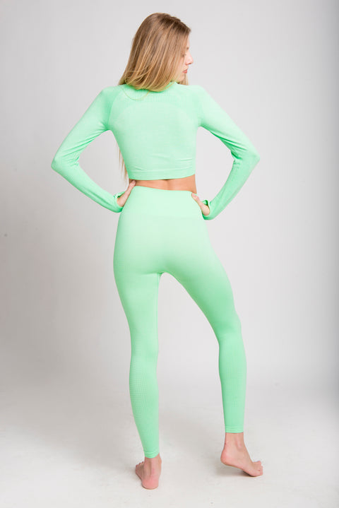 Two-piece yoga set with long sleeve top and leggings.