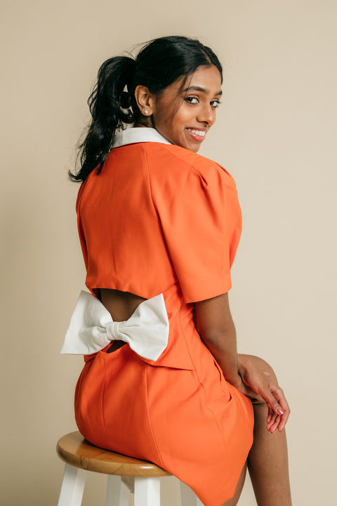 V-neck, button up jacket dress featuring cutaway back with white big ribbon.   